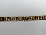 a close up of a gold chain bracelet on a white surface
