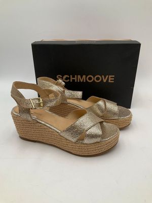 une paire de sandales dorées avec un compartiment sur le côté