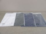 four t - shirts are lined up on a table in a row