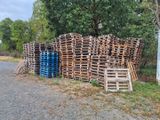de nombreuses palettes en bois empilées au bord de la route