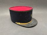 un chapeau noir orné d'un ruban rouge sur le dessus