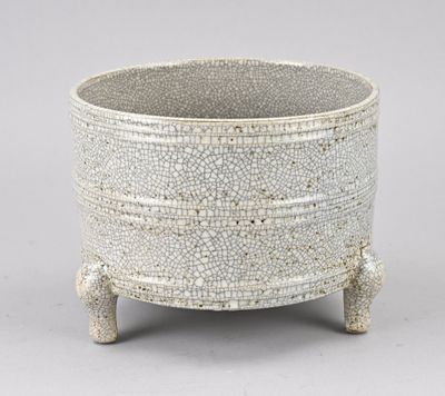 une photo d'un vase blanc posé sur un socle en bois