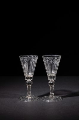 two empty wine glasses on a black table with a black background