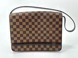 a brown and black checkered purse sitting on top of a white surface