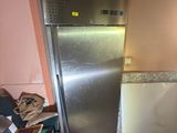 a silver refrigerator in the corner of a kitchen