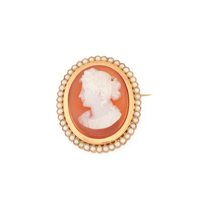 un gros plan sur une broche-camée en or et corail, ornée de perles