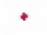 a close up of a ruby and diamond ring on a white background
