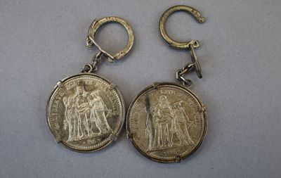 deux boucles d'oreilles en forme de pièce d'argent, ornées d'une petite pièce d'argent