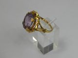a close up of a gold ring with a purple stone on it