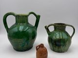two vases sitting next to each other on a white surface