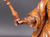 wooden statue of a woman holding a staff and a bird