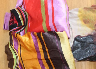 une photo d'un t-shirt de femme posé par terre à côté d'une paire de chaussettes