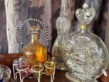 a wooden table topped with glass bottles and a silver tray