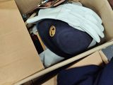 a cardboard box with a hat, gloves, and other items in it