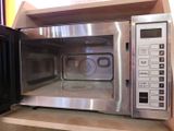 a microwave that is sitting on a shelf in a kitchen