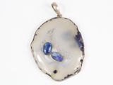 pendentif plaqué argent orné de pierres bleues sur fond blanc