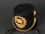 a close up of a black and gold hat on a black background