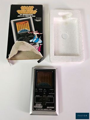 un petit appareil électronique posé sur une table à côté d'une boîte