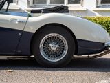 a blue and white sports car parked in front of a house