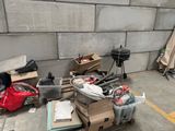 a pile of junk on the ground next to a wall