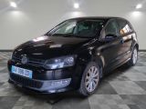 the black volkswagen polo is parked on a checkered tile floor