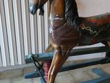 un cheval à bascule en bois posé par terre