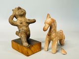 two figurines of a bear and a horse on a wooden base