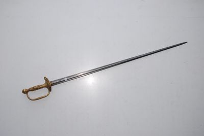 an old sword on a white surface with a gold handle