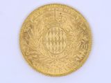 an old gold coin with a crown on it on a white surface