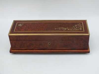une vieille boîte en bois avec une inscription dessus, posée sur une surface blanche