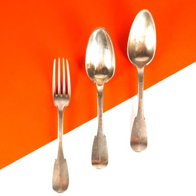 trois cuillères et une fourchette sur un fond orange et blanc