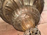 a large metal vase with a bird on top of it