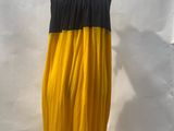 yellow and black dress on a mannequin stand in front of a white backdrop