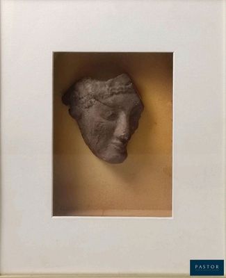 a close up of a sculpture of a face in a white frame