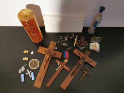 a cross, a bottle of beer, and other religious items on a table