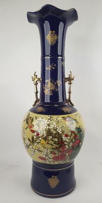 un vase bleu orné d'un motif doré et rouge