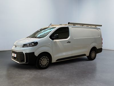 La camionnette blanche est garée dans une pièce blanche au plafond noir.