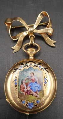a gold pocket watch with a picture of a child on it