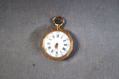 a gold pocket watch with roman numerals on it