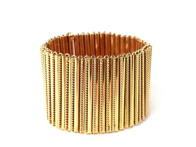 gros plan d'un bracelet en or sur fond blanc