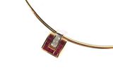 une photo d'un collier en or orné d'un pendentif en diamants rouges et blancs