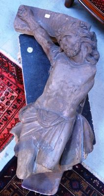 une statue représentant un homme allongé sur un tapis posé à même le sol