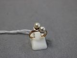 un gros plan d'une bague ornée de deux perles