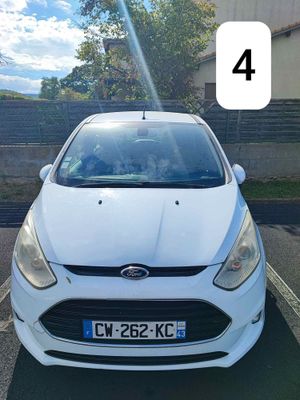 une voiture blanche garée sur un parking, portant le numéro 4