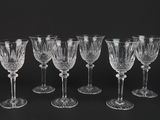 six crystal wine glasses on a black background