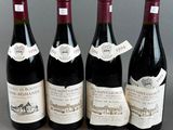 four bottles of wine are lined up on a table