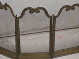 a gold fireplace screen with a mirror on it