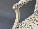 an old fashioned chair with floral fabric and a wooden frame