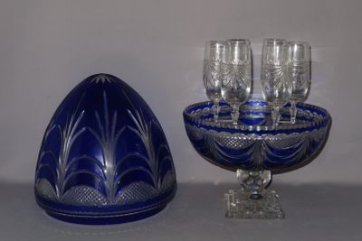 un saladier en verre bleu et des verres à vin posés sur une table