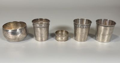 quatre coupes en argent sont alignées sur une surface blanche
